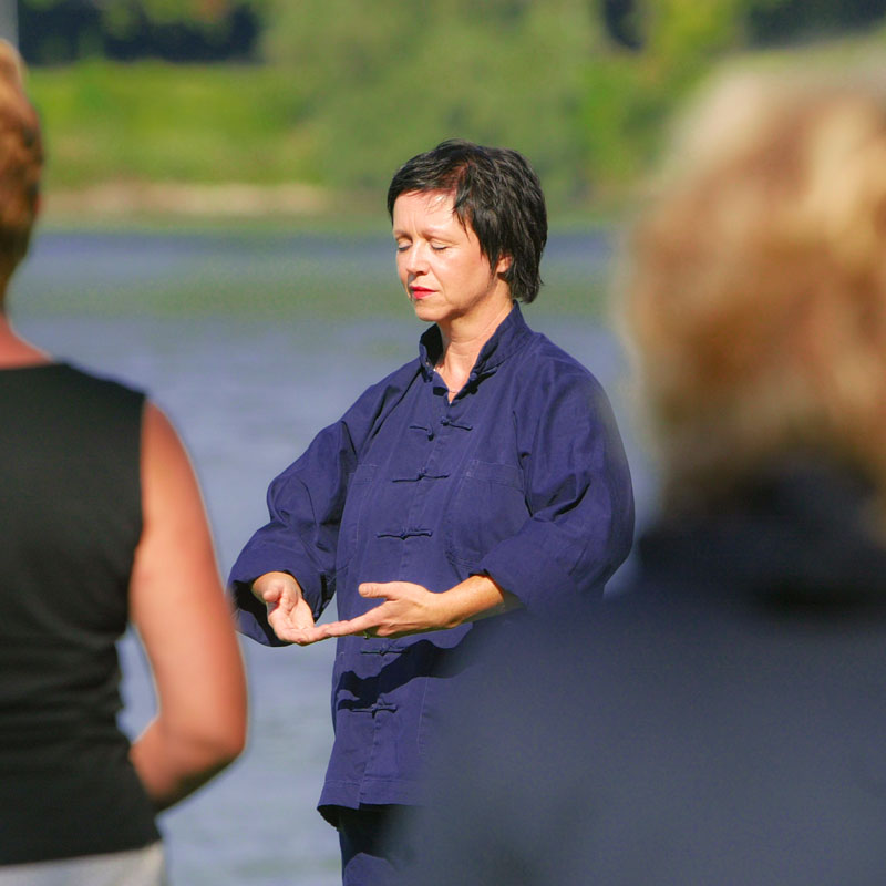 Regina de Rossi zeigt eine Qi-Gong-Übung in Nordsee-Dünen